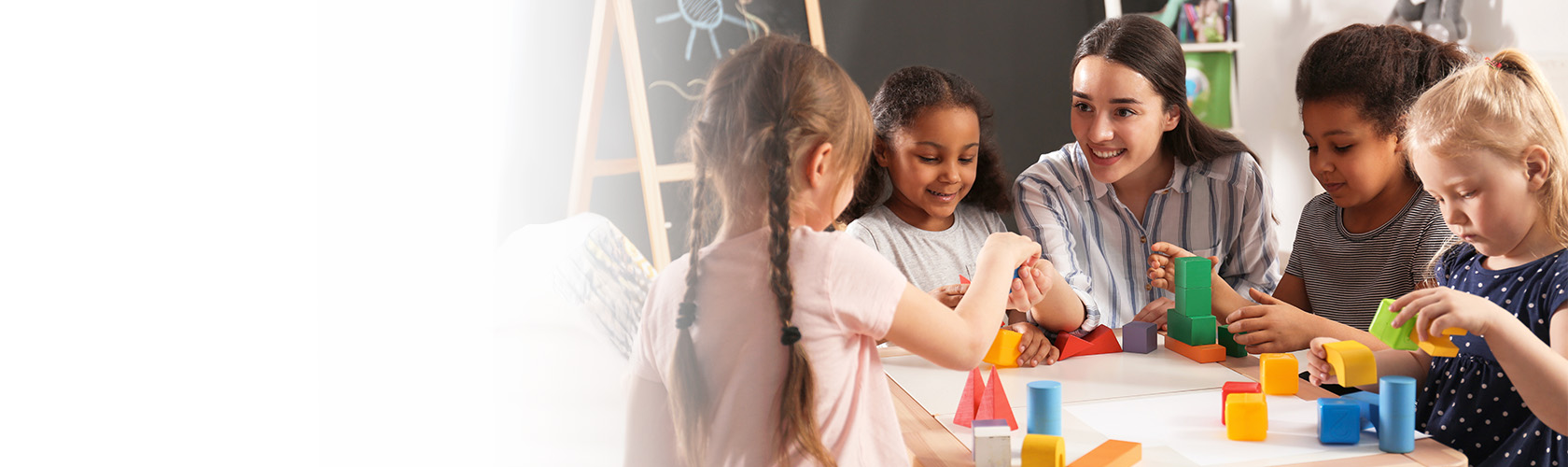 Teacher and children playing with blocks at a table