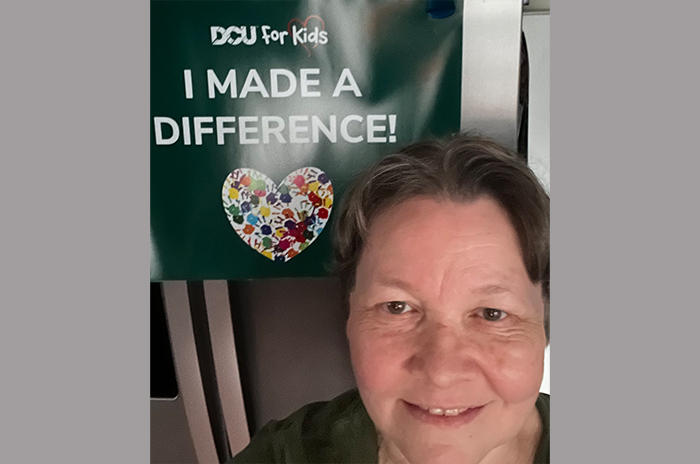 woman in front of DCU For Kids I made a difference poster