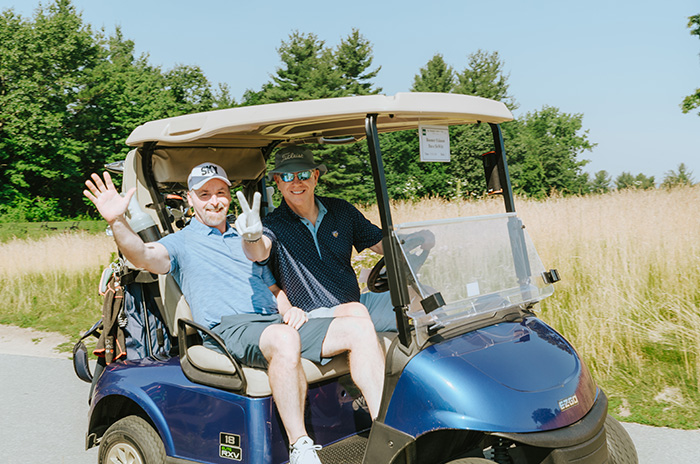 two men riding a golf cart
