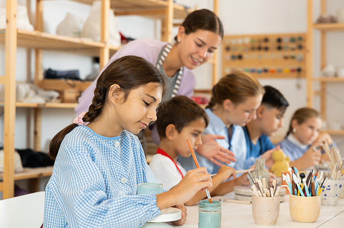 Teacher supervising children painting