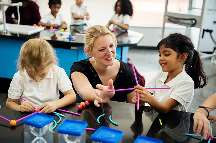 Teacher preparing science models with students